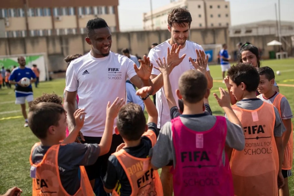 Samuel Eto'o and Kaká high-fiving children at a FIFA Football for Schools event