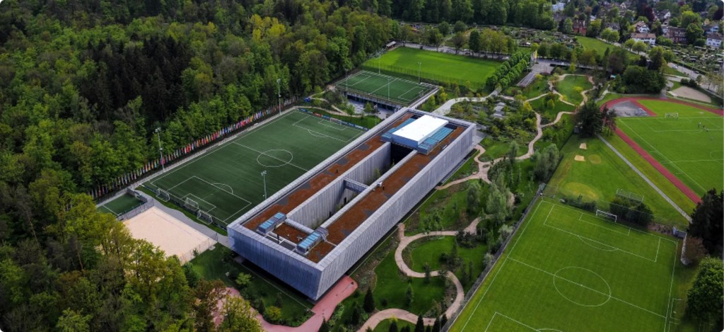 Aerial view of the FIFA headquarters in Zurich surrounded by football pitches and forest